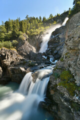 Fototapeta na wymiar The Rutor waterfall, in Valle d'Aosta, descends impetuously among the rocks
