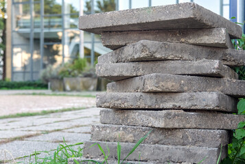 Konzept Baustelle und Sanierung: Aufeinander gestapelte Pflastersteine oder Waschbetonplatten auf...
