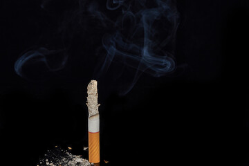 One smoking cigarette on a black background.