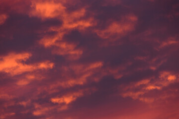 Stormy clouds and crimson sunset. Purple glow on the evening clouds. Sky patterns as background.