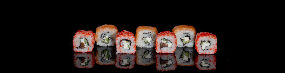 Philadelphia roll with salmon, cheese and cucumber on a black background with reflection. Sushi Philadelphia