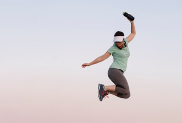 Fototapeta premium woman jumping while doing sport on a blue background