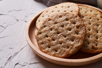 whole grain wheat round crackers on white table background