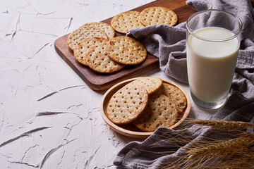 whole grain wheat round crackers and milk on white table background
