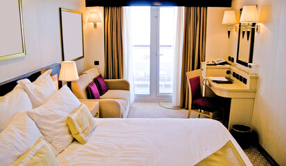 View into balcony cabin or stateroom with king or queen double bed and living room area on classic...