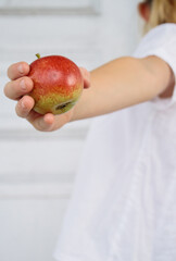 Little girl holding a red apple in her hands, caucasian girl, child, white background