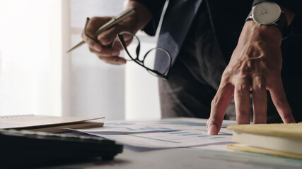 Close up of Businessman investment consultant analysis company annual financial report balance sheet statement working with documents graphs. Concept picture of economy, marketing