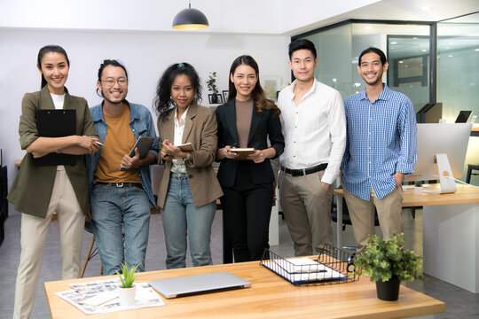 Portrait of successful group of young Asian business people smiling and looking at camera in the office