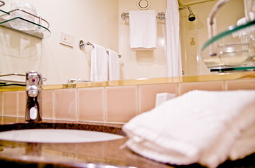 View into classic British interiors bathroom with towels, sink and racks in cabin or stateroom of...