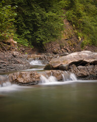 Fototapeta na wymiar Beautiful cascade of mountain waterfall in Ukrainian Carpathians