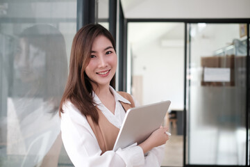 Secretary woman holding a tablet computer and smile on face.