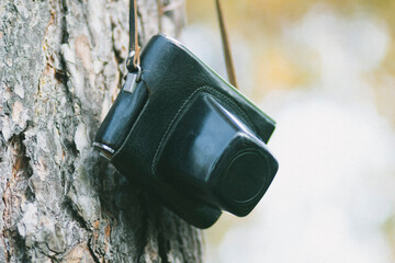 Old Soviet retro camera in a case on a tree