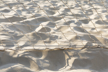Stretched mesh on a white sand background, sunlight, texture, outdoors, beach vacation, sport.