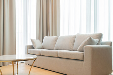 close up light beige fabric sofa with warm cozy morning light from big window home interior background