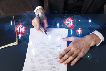 Businessman in suit signs contract. Double exposure with world map hologram. Man signing agreement...