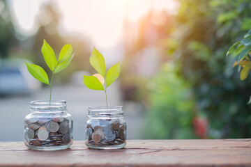 Saving money by hand puting coins in jug glass