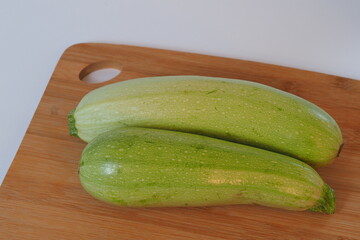 Vegetables. The courgettes are green on a wooden board. High