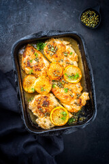 Traditional Italian deep-fried chicken piccata with capper and lemon slices offered as top view in...