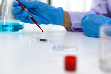 Fototapeta premium Scientist holding Coronavirus covid-19 infected blood sample tube DNA testing of the blood in the laboratory with blood sample collection tubes and syringe Coronavirus Covid-19 vaccine research.