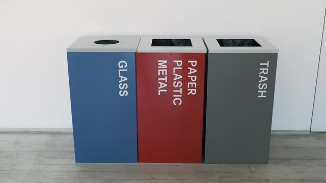 Colorful, plastic garbage bins, with recycle logo stacked in the office. Sorting, metal, plastic, glass, paper, organic. Plastic bins, garbage cans recycling 4k