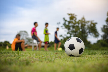 Action sport outdoors of kids having fun playing soccer football for exercise in community rural...