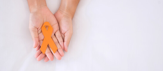 Leukemia, Kidney cancer day, world Multiple Sclerosis, CRPS, Self Injury Awareness month, woman holding Orange Ribbon for supporting people living and illness. Healthcare and World cancer day concept