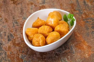 Sweet tasty profiteroles heap in the bowl