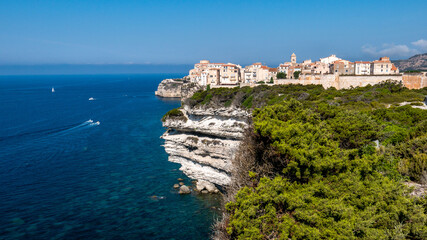 Corsica Bonifacio white cliff with citadel old town facing the Mediterranean Sea during sunny day.