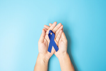 March Colorectal Cancer Awareness month, Man holding dark Blue Ribbon for supporting people living and illness. Healthcare, hope and World cancer day concept