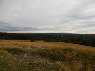 A field on a hill and a panoramic view of the surroundings, a beautiful summer landscape