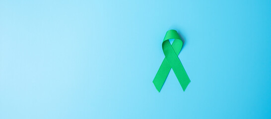 green Ribbon color on blue background for supporting people living and illness. Liver, Gallbladders bile duct Cancer and organ donation Awareness month concept