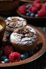 chocolate muffins and fresh berries for dessert, vertical
