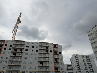 Fototapeta na wymiar Construction site view. Multi-storey monotonous houses against the skye.