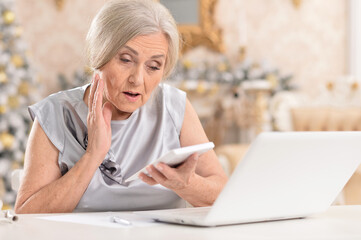 Close up portrait of senior woman with laptop