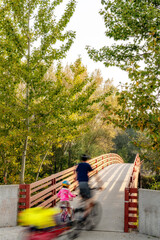 Parent and child ride their bikes across a Boise River bridge