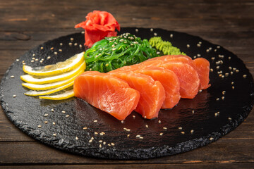Salmon sashimi on black dish