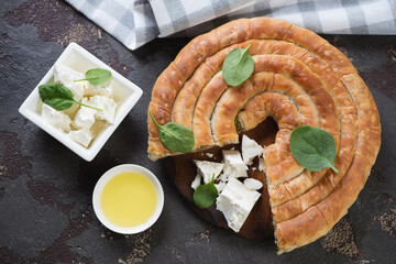 Above view of sliced spanakopita or greek spiral spinach and feta cheese pie, horizontal shot on a...