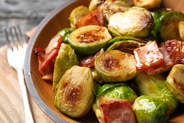 Delicious fried Brussels sprouts with bacon in bowl, closeup