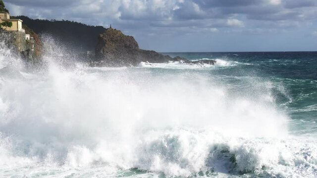 devastating and spectacular sea storm in Framura, Liguria Cinque Terre - sea waves crash on the rocks of the coast creating an explosion of water 