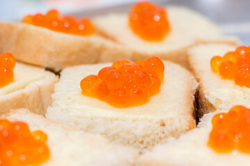 Sandwich with red caviar. Slice of bread with butter and salmon roe. Expensive delicious appetizer with seafood delicacy.