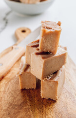 Raw vegan peanut butter fudge on a white marble background.