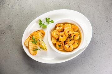 Shrimp stir fry in a wok with serving plates in the background