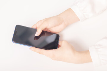 female hands with a smartphone at a table