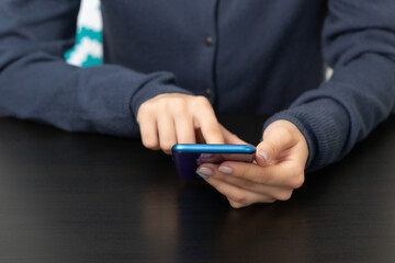 the girl with the phone at the table presses the screen