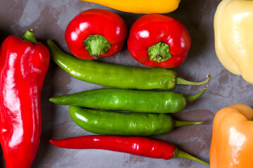 Assortment of peppers on the grey table. Top view