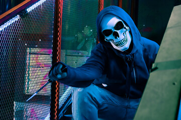 Scary murderer wearing skull mask and holding knife