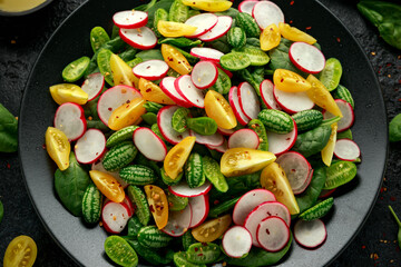 Cucamelon salad with radish, tomato, spinach and mustard dressing. Healthy food.