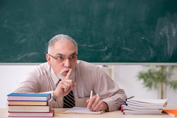 Old male teacher in the classroom