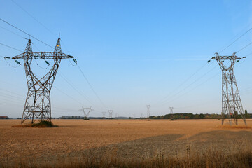 Group of electric pylons, high voltage lines. Overhead cables carrying electricity to cities.