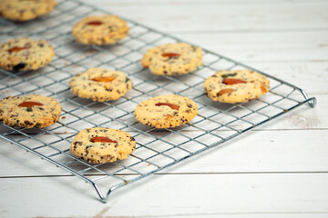 Homemade delicious cookies with almonds on top arrange on stainless griddle